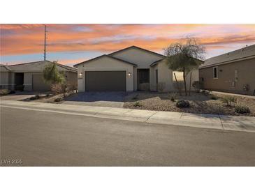 Charming single-story home boasts desert landscaping and a two-car garage under a lovely sunset at 2255 Woodbluff Ave, North Las Vegas, NV 89086
