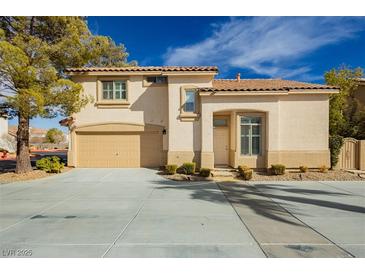 Charming two-story home featuring a tan exterior, tile roof, attached garage, and landscaped front yard in a sunny neighborhood at 2345 Cliffwood Dr, Henderson, NV 89074