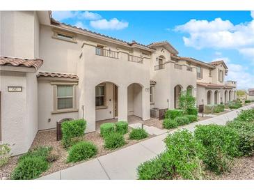 Inviting townhome featuring stucco exterior, arched entry, and well-maintained landscaping at 56 Lomita Heights Dr, Las Vegas, NV 89138
