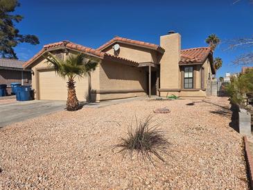 Single story home with desert landscaping, garage, and red tile roof at 7324 Saybrook Point Dr, Las Vegas, NV 89128