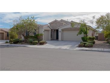 Charming single-story home featuring a stone facade, well-manicured landscaping, and three-car garage at 1617 Meadow Bluffs Ave, Henderson, NV 89014