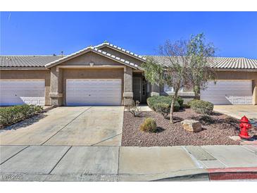 Charming townhome featuring a two-car garage, desert landscaping, and a welcoming front entry at 211 Crown Imperial St, Henderson, NV 89074