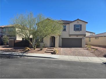Charming two-story home with a well-manicured front yard and a two-car garage at 981 Soaring Moon Dr, Henderson, NV 89015