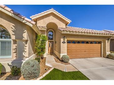 Charming single-story home with a tile roof, arched entry, and well-manicured landscaping at 105 Eagleview Ct, Henderson, NV 89074