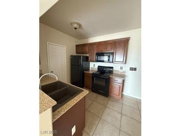 Cozy kitchen featuring granite counters, tile floors, wooden cabinets and modern, black appliances at 3550 Bay Sands Dr # 2087, Laughlin, NV 89029