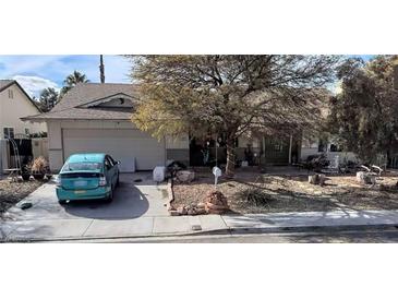 Charming single story house featuring a front yard with desert landscaping and a light blue car in the driveway at 4637 Balfour Dr, Las Vegas, NV 89121