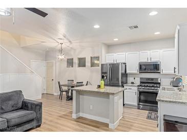 Modern kitchen features stainless steel appliances, granite countertops, and center island perfect for entertaining at 6525 Raven Hall St, North Las Vegas, NV 89084