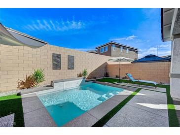 Inviting backyard with a plunge pool, waterfall feature, and lounge area at 690 Monroe Hill Pl, Henderson, NV 89011