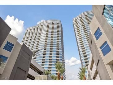 Low angle view of towering condo building with clean architectural lines against a blue sky with palm trees at 4525 Dean Martin Dr # 607, Las Vegas, NV 89103