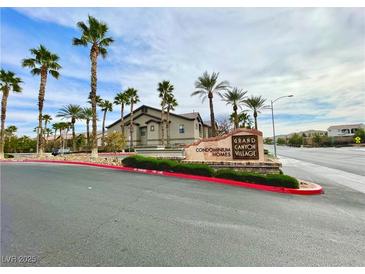 A Grand Canyon Homes Village condominium community entrance lined with lush palm trees at 8250 N Grand Canyon Dr # 1139, Las Vegas, NV 89166