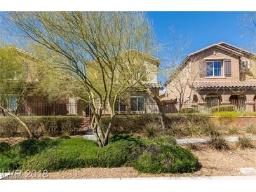 Inviting two-story home featuring desert landscaping, private fences, and convenient sidewalk access at 10085 S Riley St, Las Vegas, NV 89178