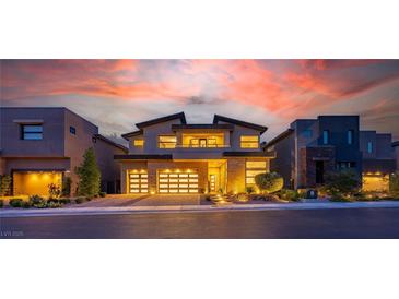 Stunning two-story home with a three-car garage, stone accents, and professional landscaping at sunset at 10748 Steel Ridge Ct, Las Vegas, NV 89135