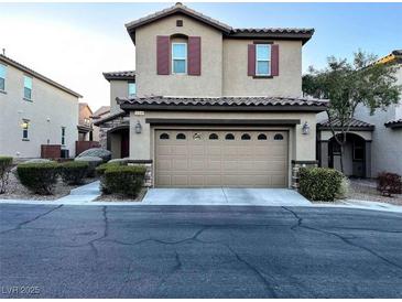 Inviting two-story home featuring a two-car garage, landscaped yard, and classic architectural details at 10941 Prudhoe Bay St, Las Vegas, NV 89179