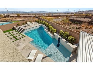 Inviting backyard pool with turf, desert landscaping, sun-bathing chairs, steps, and views of the surrounding landscape at 11943 Rockview Point St, Las Vegas, NV 89138