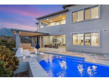 Inviting backyard pool and patio with modern lounge chairs, perfect for outdoor relaxation and entertainment at 11943 Rockview Point St, Las Vegas, NV 89138