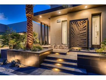 Contemporary home featuring a grand entrance with a tall palm tree and modern architectural details at 678 Blackrock Rim Dr, Henderson, NV 89012
