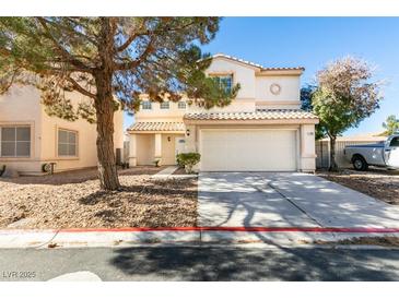 Inviting two-story home featuring a classic design, two-car garage, and a well-maintained front yard at 7752 Orchard Wood Ct, Las Vegas, NV 89131