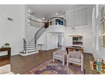 Bright living room featuring a grand staircase, hardwood floors, and elegant decor at 1754 Quiver Point Ave, Henderson, NV 89012