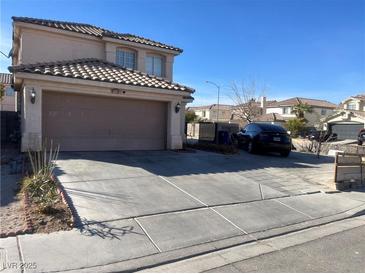 Two-story home with a tile roof, attached two-car garage, and a spacious driveway on a sunny day at 2291 Grannis Ln, Las Vegas, NV 89104