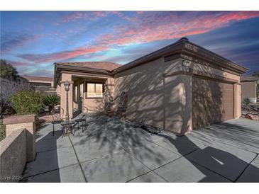 Charming one-story home featuring a spacious driveway, desert landscaping, and warm lighting at 2728 Goldcreek St, Henderson, NV 89052