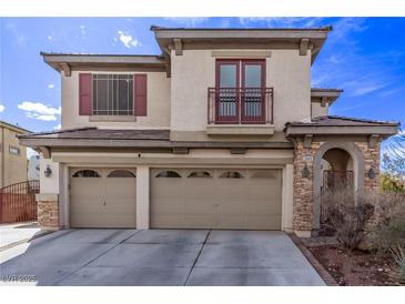 Inviting two-story home with a three-car garage, stone accents, and a charming balcony at 3009 Little Crimson Ave, North Las Vegas, NV 89081