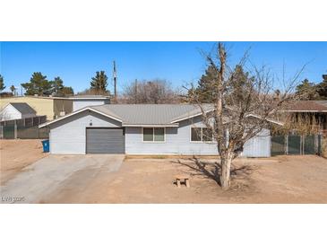 Charming single-story home featuring a metal roof, attached garage, and spacious yard at 432 Bonelli Ave, Overton, NV 89040