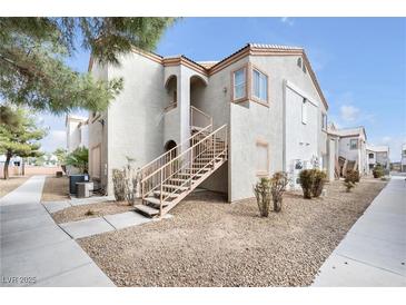 Beige stucco condo building featuring multiple units and exterior staircases on a sunny day at 4655 Gold Dust Ave # 139, Las Vegas, NV 89120