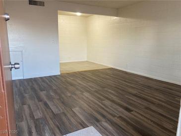 Open-concept living room with modern wood flooring and neutral wall colors at 565 S Royal Crest Cir # 15, Las Vegas, NV 89169