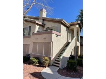 Inviting home exterior featuring a private balcony with stair access and beautiful desert landscaping at 5710 E Tropicana Ave # 2047, Las Vegas, NV 89122