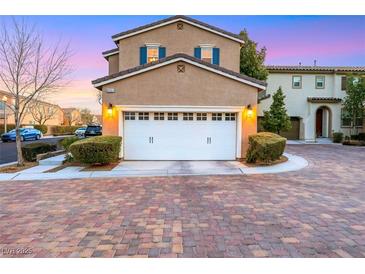 Inviting two-car garage with manicured shrubs, and a beautiful brick driveway at 9151 Mount Wilson St, Las Vegas, NV 89113