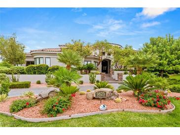 Beautiful single-Gathering home with lush landscaping and desert foliage around the circular driveway at 9825 Glenrock Dr, Las Vegas, NV 89134