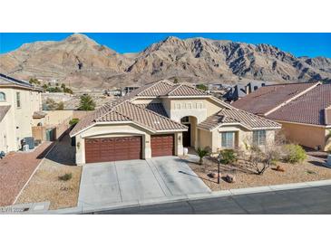 Stunning single-story home boasting a three-car garage and beautifully landscaped front yard with mountain views at 1484 Midnight Cowboy Ct, Las Vegas, NV 89110