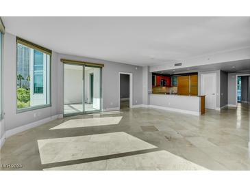 Bright living room with travertine floors, a modern kitchen, and large windows overlooking a city view at 322 Karen Ave # 201, Las Vegas, NV 89109