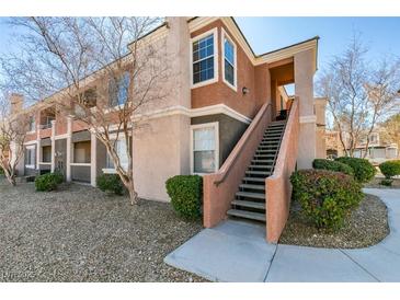 Inviting condo featuring manicured landscaping, two stories, and exterior stairs leading to the upper level at 7700 Constanso Ave # 204, Las Vegas, NV 89128