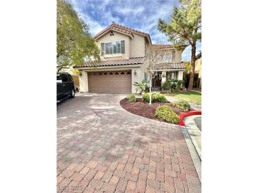 Charming two-story home features a brick driveway, a two-car garage and well-maintained landscaping at 11027 Dornoch Castle St, Las Vegas, NV 89141