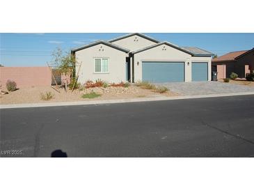 Charming single-story home with desert landscaping, a brick perimeter wall, and a two-car garage at 1580 S Outlaw St, Pahrump, NV 89060