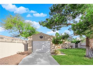 A one-car garage with a concrete driveway sits in front of a well-maintained lawn and mature trees at 2136 Velvet Hill Ave, Las Vegas, NV 89106