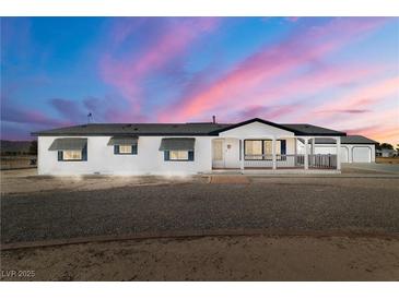 Charming single-story home featuring a covered porch, desert landscaping, and an inviting facade at 3420 Malibou Ave, Pahrump, NV 89048