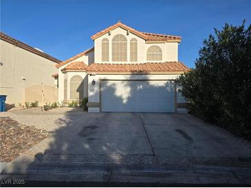 Charming two-story home featuring a terracotta roof, arched windows, and a two-car garage at 3550 Leor Ct, Las Vegas, NV 89121