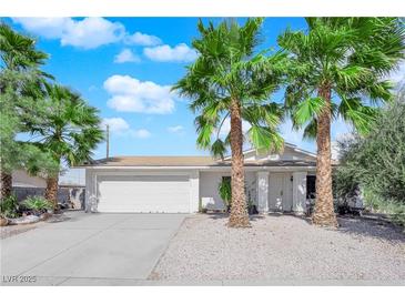 Charming single-story home featuring a well-maintained front yard, palm trees and a two car garage at 3936 Savoy Ct, Las Vegas, NV 89115