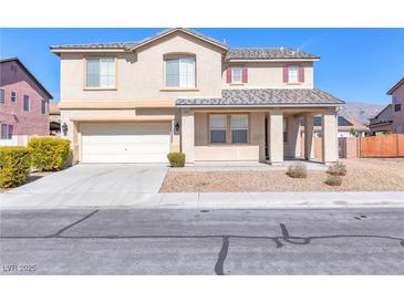 Two-story home featuring a two-car garage, covered porch, and low-maintenance landscaping at 5616 Dunshee Vista Ave, Las Vegas, NV 89131