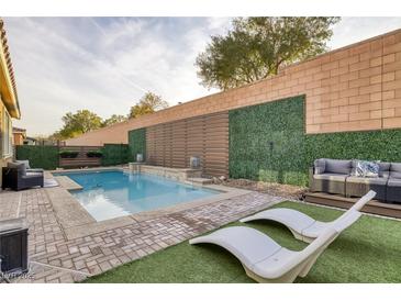 Inviting backyard pool area featuring lounge chairs, privacy landscaping, and comfortable seating for outdoor relaxation at 6021 Vista Clara St, Las Vegas, NV 89148