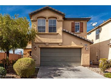 Two-story home with tan stucco, a two car garage, and desert landscaping at 8699 Grand Sequoia St, Las Vegas, NV 89139