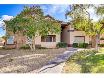 Inviting condo exterior with desert landscaping, mature trees, and a charming walkway leading to the entrance at 231 W Horizon Ridge Pkwy # 2413, Henderson, NV 89012