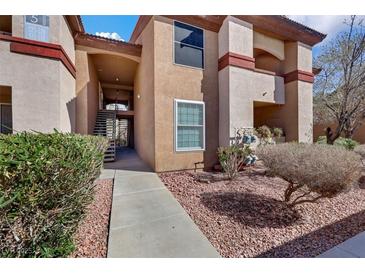 Condo exterior featuring tan stucco, red rock landscaping, and staircase to upper units at 231 W Horizon Ridge Pkwy # 527, Henderson, NV 89012