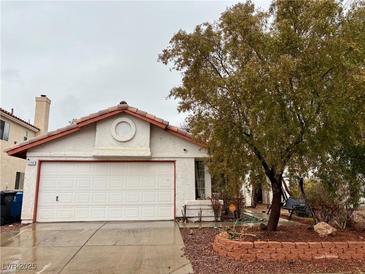 Charming single Gathering home featuring a two-car garage and a well-kept front yard with a mature shade tree at 2709 Camphor Tree St, Las Vegas, NV 89108