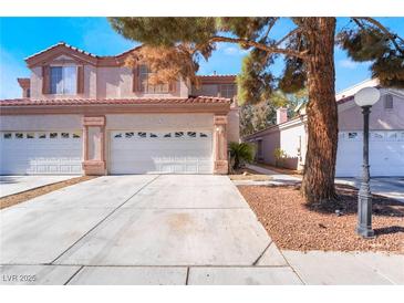 Charming two-story home featuring a three-car garage, complemented by a tree-lined yard and a meticulously maintained driveway at 4451 Tomer Ln, Las Vegas, NV 89121