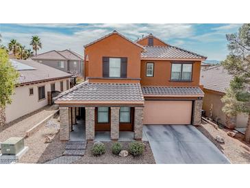 Two-story home featuring an attached two car garage and covered front porch with decorative stone columns at 1125 Via Canale Dr, Henderson, NV 89011