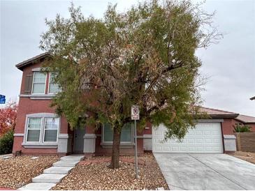 Charming two-story red home with well-maintained landscaping and a two-car garage in a residential neighborhood at 5236 El Prado Heights St, North Las Vegas, NV 89081