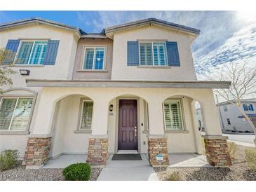 Charming two-story home featuring a welcoming front porch with stone accents and blue shutters at 8562 Insignia Ave # 102, Las Vegas, NV 89178